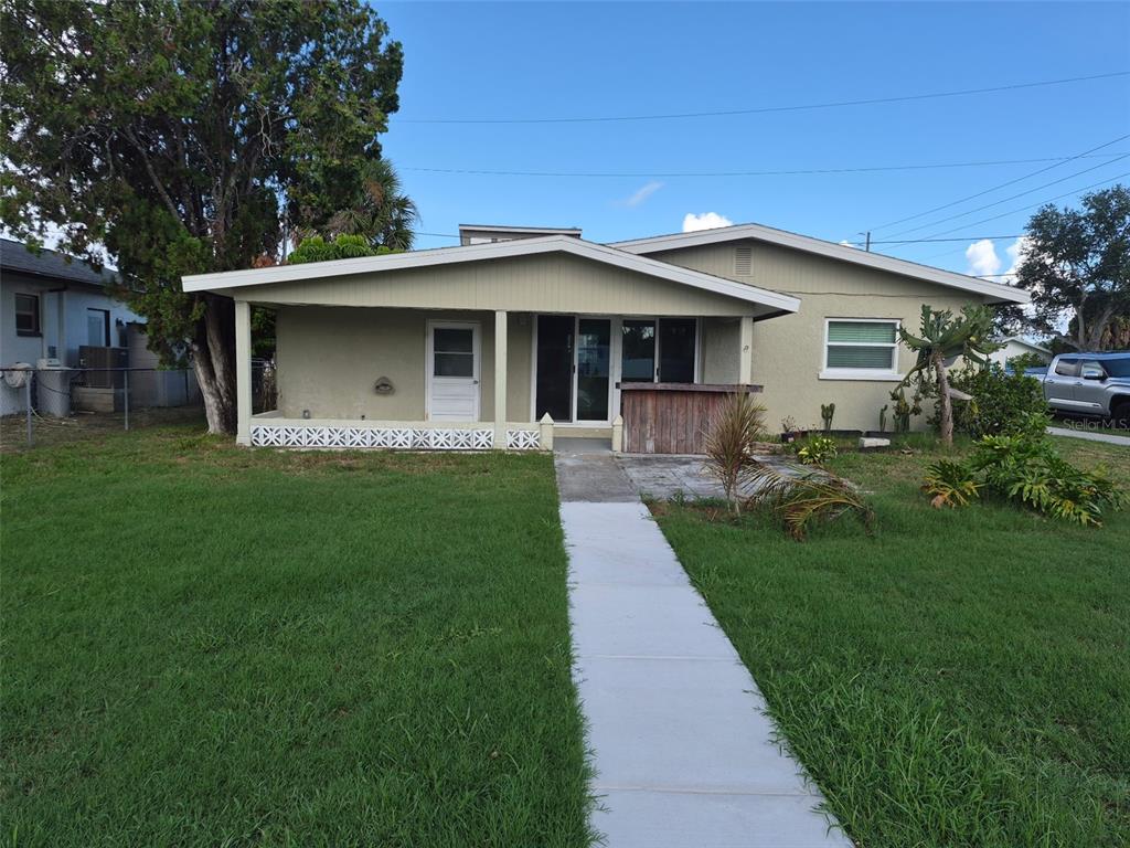 A single-story house with a covered porch, a concrete walkway, and a grassy front yard — 13934 SOMMERS AVENUE, HUDSON, FL