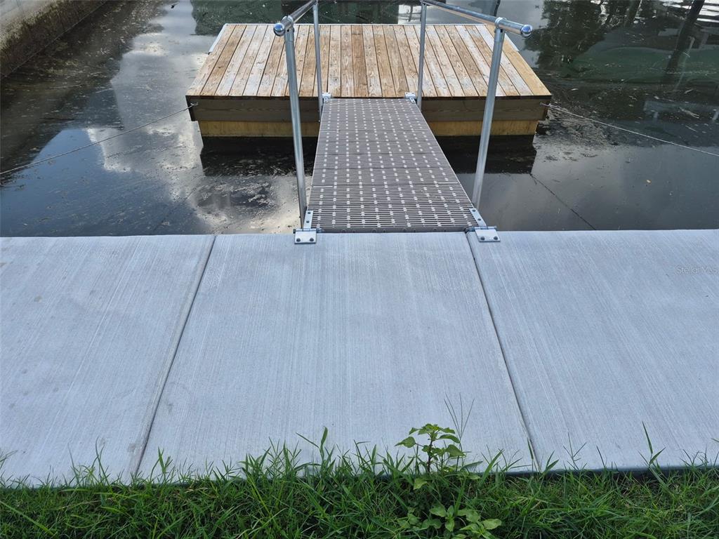 A concrete walkway leads to a metal ramp connecting to a wooden floating dock — 13934 SOMMERS AVENUE, HUDSON, FL