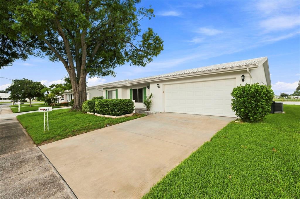 A single-story house with a white exterior, a garage, and a large tree in front — 3555 93RD AVENUE N UNIT 6, PINELLAS PARK, FL