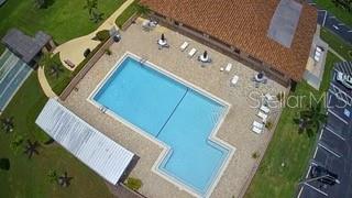 An aerial view shows a rectangular swimming pool with a patio, lounge chairs, and building — 3555 93RD AVENUE N UNIT 6, PINELLAS PARK, FL