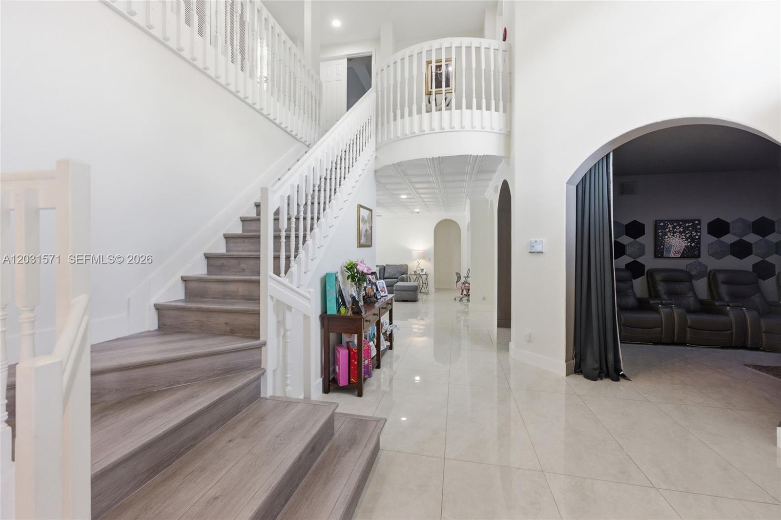 A grand foyer features a wood-tread staircase, white railings, and polished tile flooring — 3511 SW 145th Ave, Miramar FL 33027, MIRAMAR, FL