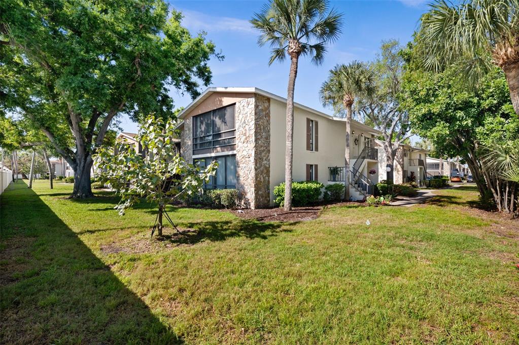 A two-story apartment building with stone accents and palm trees on a grassy lawn — 5400 34TH STREET W UNIT I3, BRADENTON, FL
