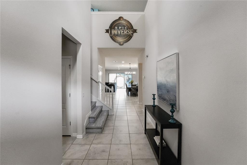 A tiled entryway leads to a staircase and a dining area with a high ceiling — 1885 GOBI DRIVE, KISSIMMEE, FL