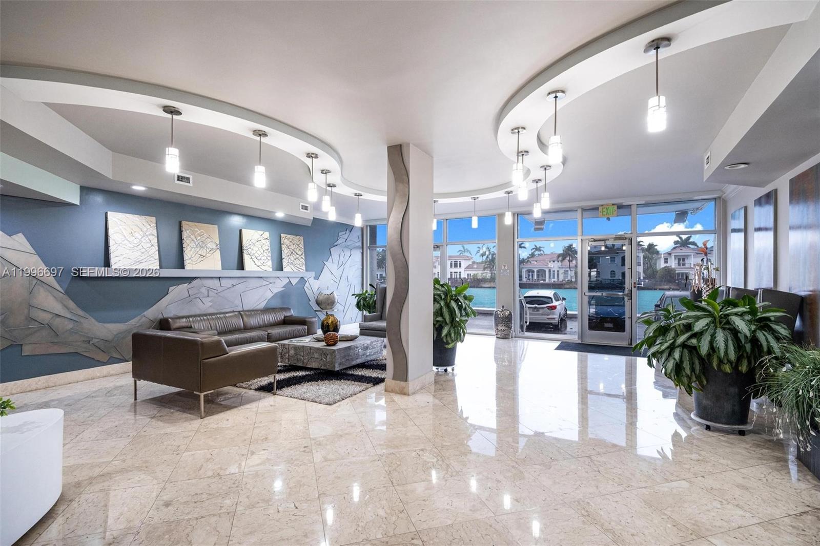 A modern lobby features a curved ceiling, marble floors, a leather sofa, and waterfront views — 1500 S Ocean Dr # G10, Hollywood FL 33019, HOLLYWOOD, FL