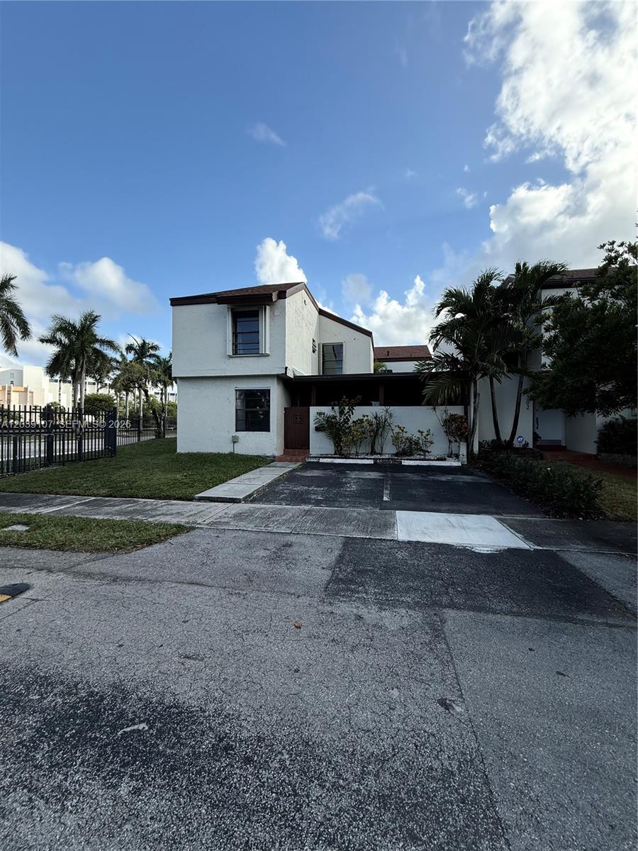 A two-story residential building with a paved driveway and palm trees under a blue sky — 9700 NW 6th Ln # 9700, Miami FL 33172, MIAMI, FL