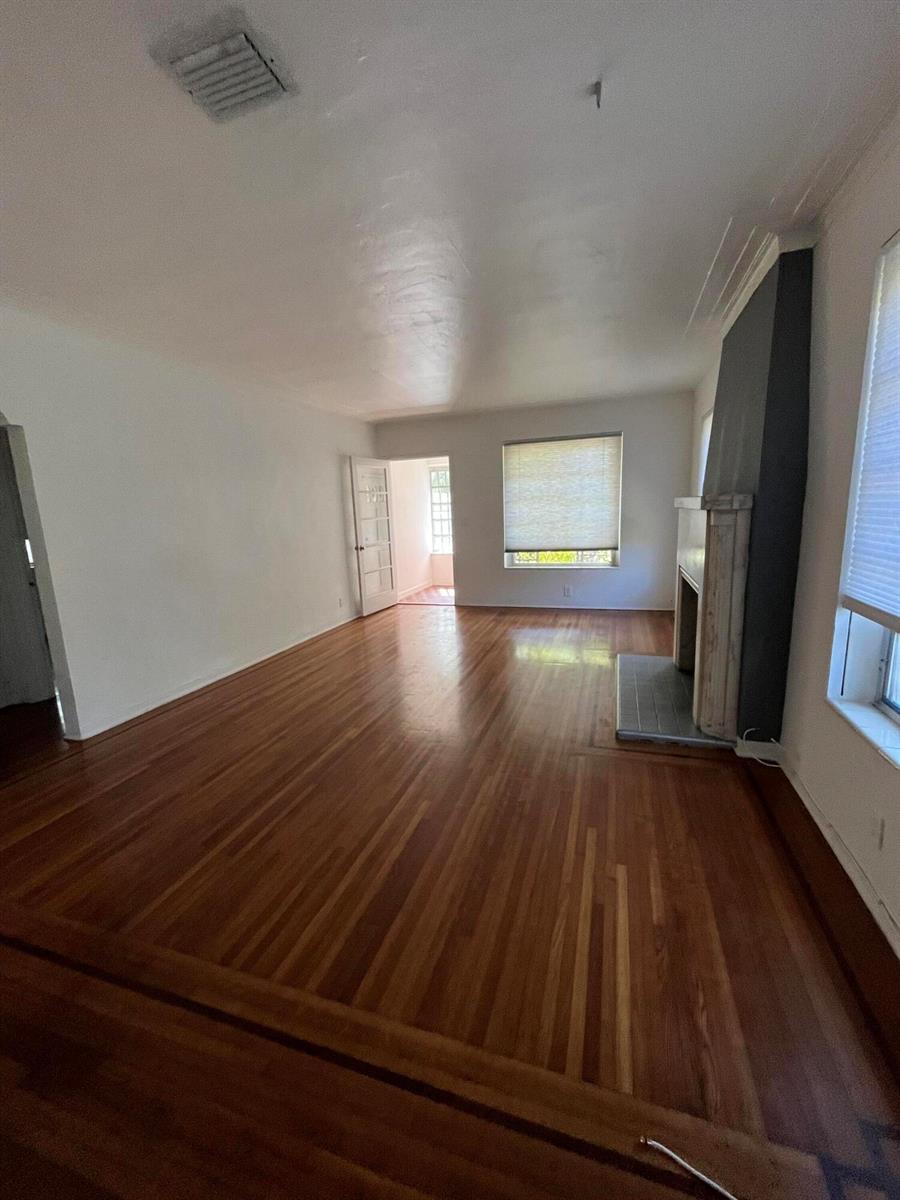 A living room features hardwood floors, a fireplace with a dark accent wall, and windows — 175 SW 25th Road, Miami FL 33129, MIAMI, FL