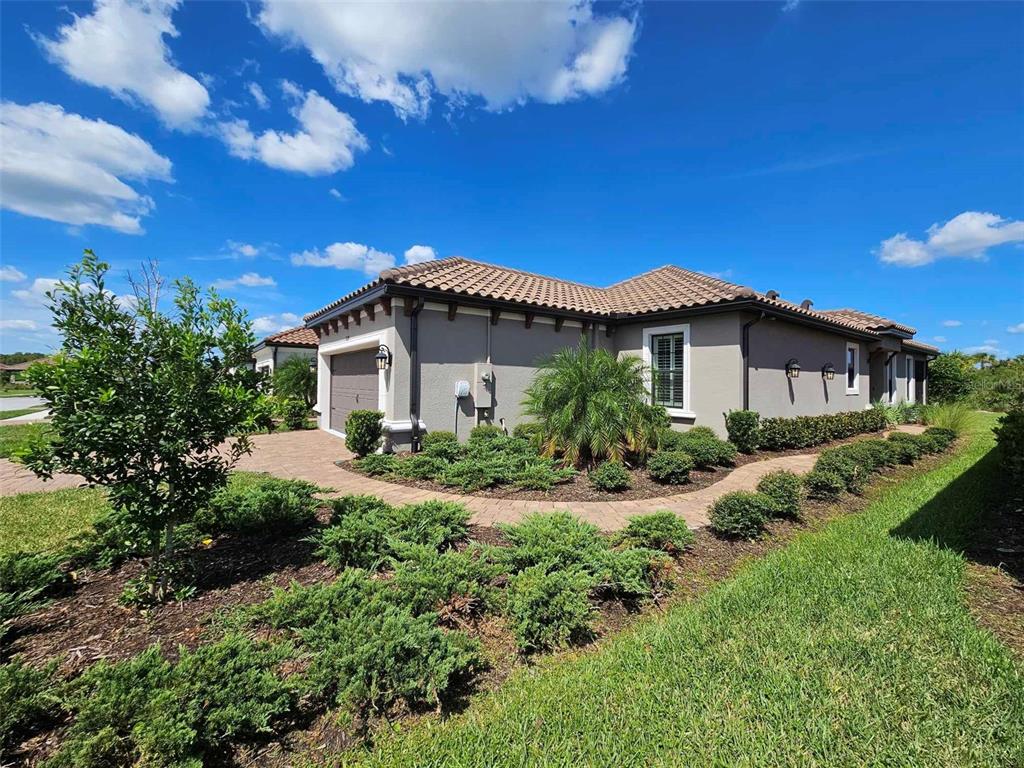A single-story house with a tile roof, gray stucco walls, and a paved walkway — 3270 FRANCOA DRIVE, ODESSA, FL