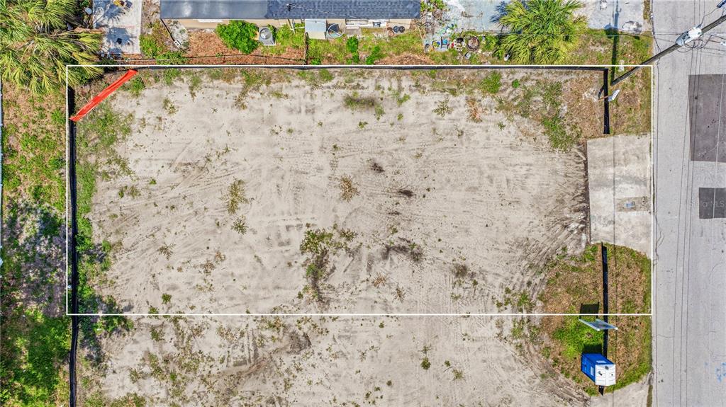 An aerial view of a vacant, rectangular dirt lot bordered by a fence and road — 1712 W SAINT CONRAD STREET, TAMPA, FL