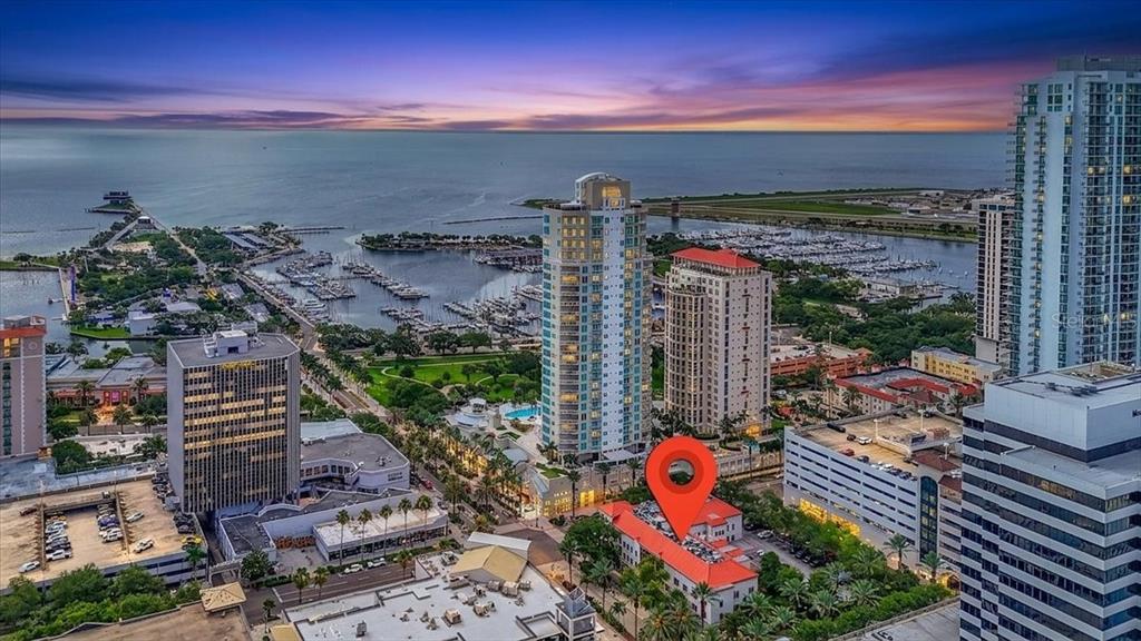 An aerial view shows a city skyline, a marina, and a red-roofed building marked — 100 2ND AVENUE N UNIT 350, ST PETERSBURG, FL