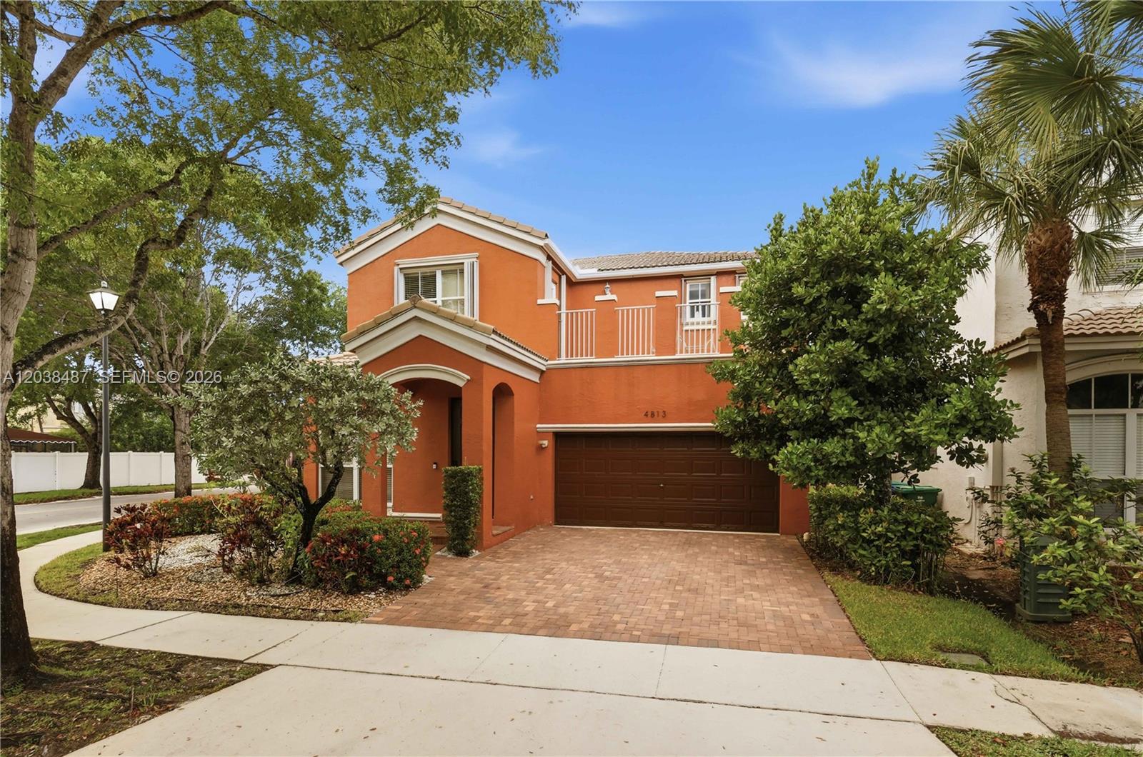 A two-story orange house features a brown garage door and a brick-paved driveway — 4813 SW 155th Ter, Miramar FL 33027, MIRAMAR, FL