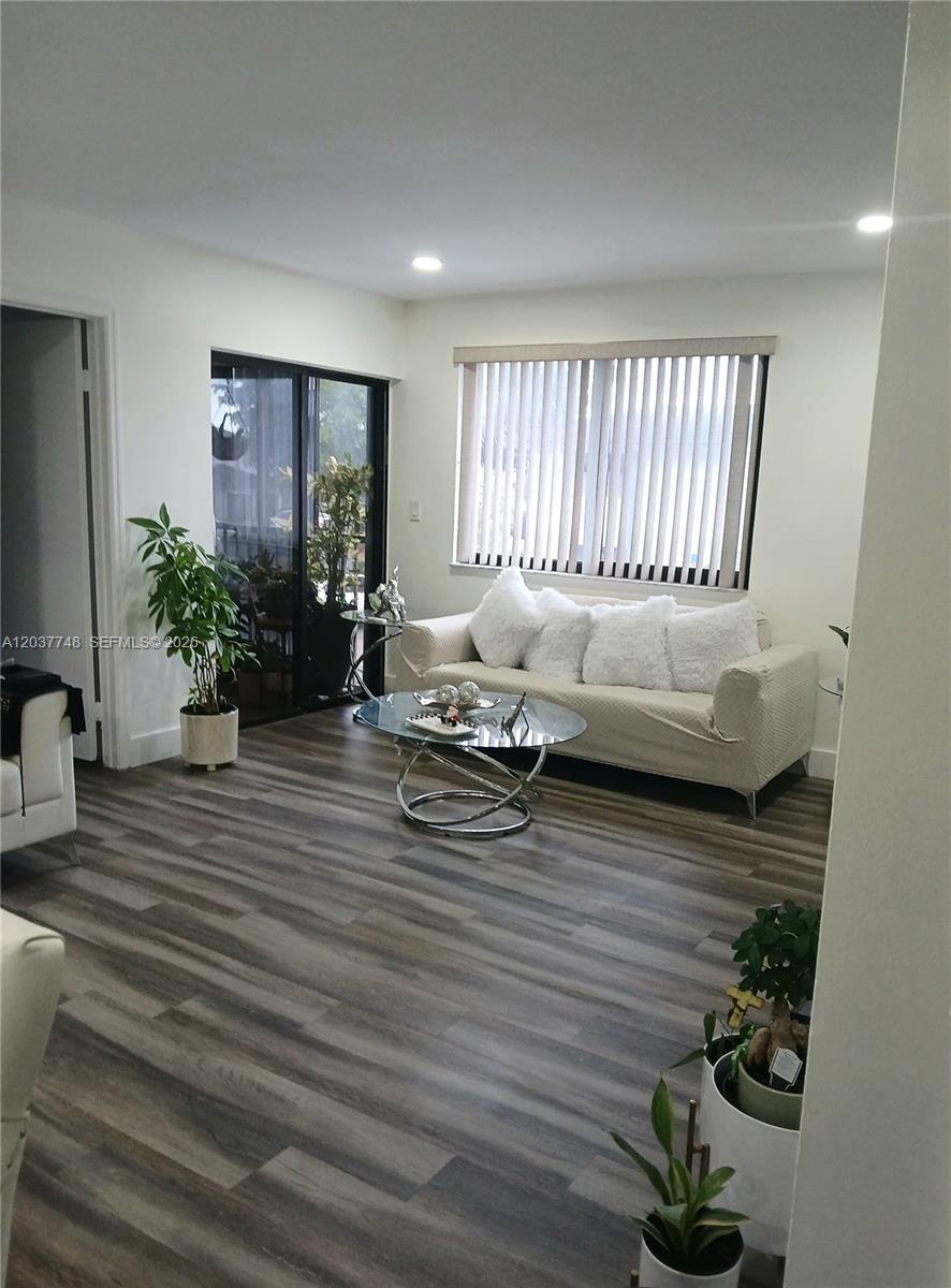 A living room features wood-look flooring, a beige sofa, and a glass coffee table — 6365 W 27th Ct # 8, Hialeah FL 33016, HIALEAH, FL