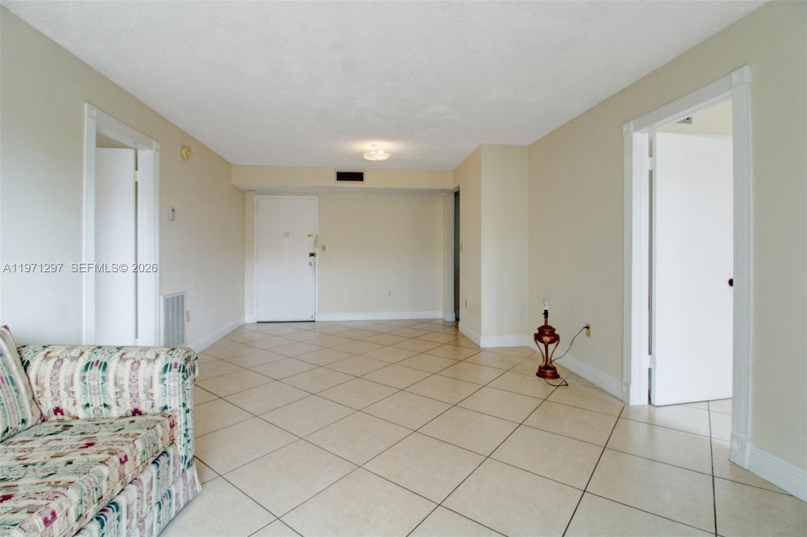 A living room features beige tile flooring, light-colored walls, and two open doorways — 4717 NW 7th St # 10, Miami FL 33126, MIAMI, FL