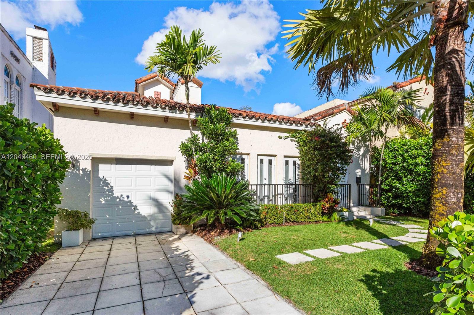 A single-story house with a white stucco exterior, tile roof, and a paved driveway — 737 Alhambra Cir, Coral Gables FL 33134, CORAL GABLES, FL