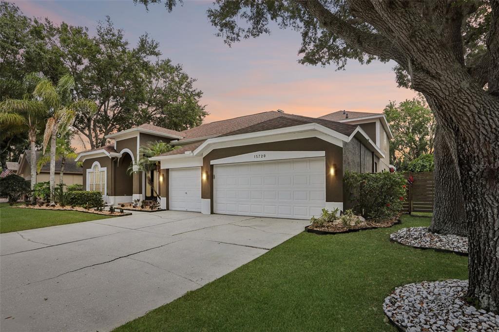 A two-story house with a brown exterior, white trim, and a three-car garage — 15720 BEREA DRIVE, ODESSA, FL