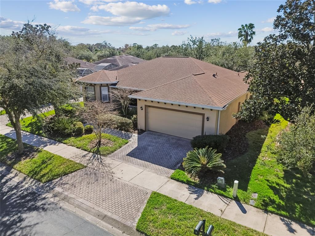 A single-story house with a tan exterior, a two-car garage, and landscaped front yard — 308 BEACON AVENUE, KISSIMMEE, FL