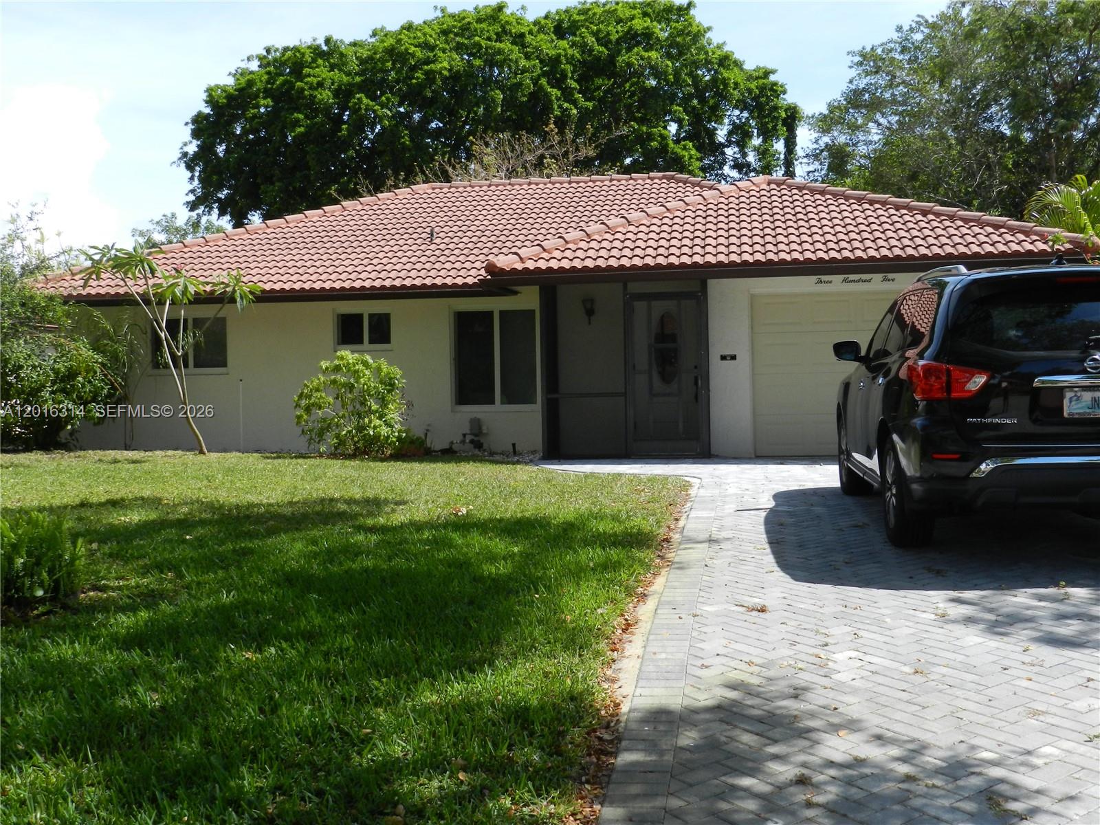 A single-story house with a tiled roof, white exterior, and a paved driveway — 305 NW 42nd St, Boca Raton FL 33431, BOCA RATON, FL