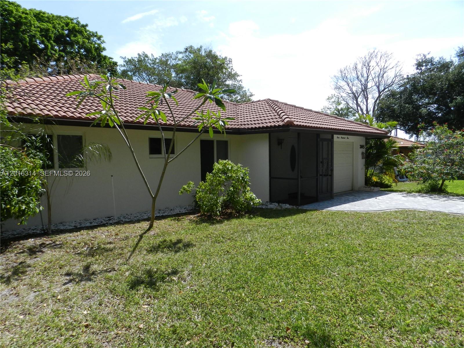 A single-story house with a tiled roof, white exterior, and a screened-in front entryway — 305 NW 42nd St, Boca Raton FL 33431, BOCA RATON, FL
