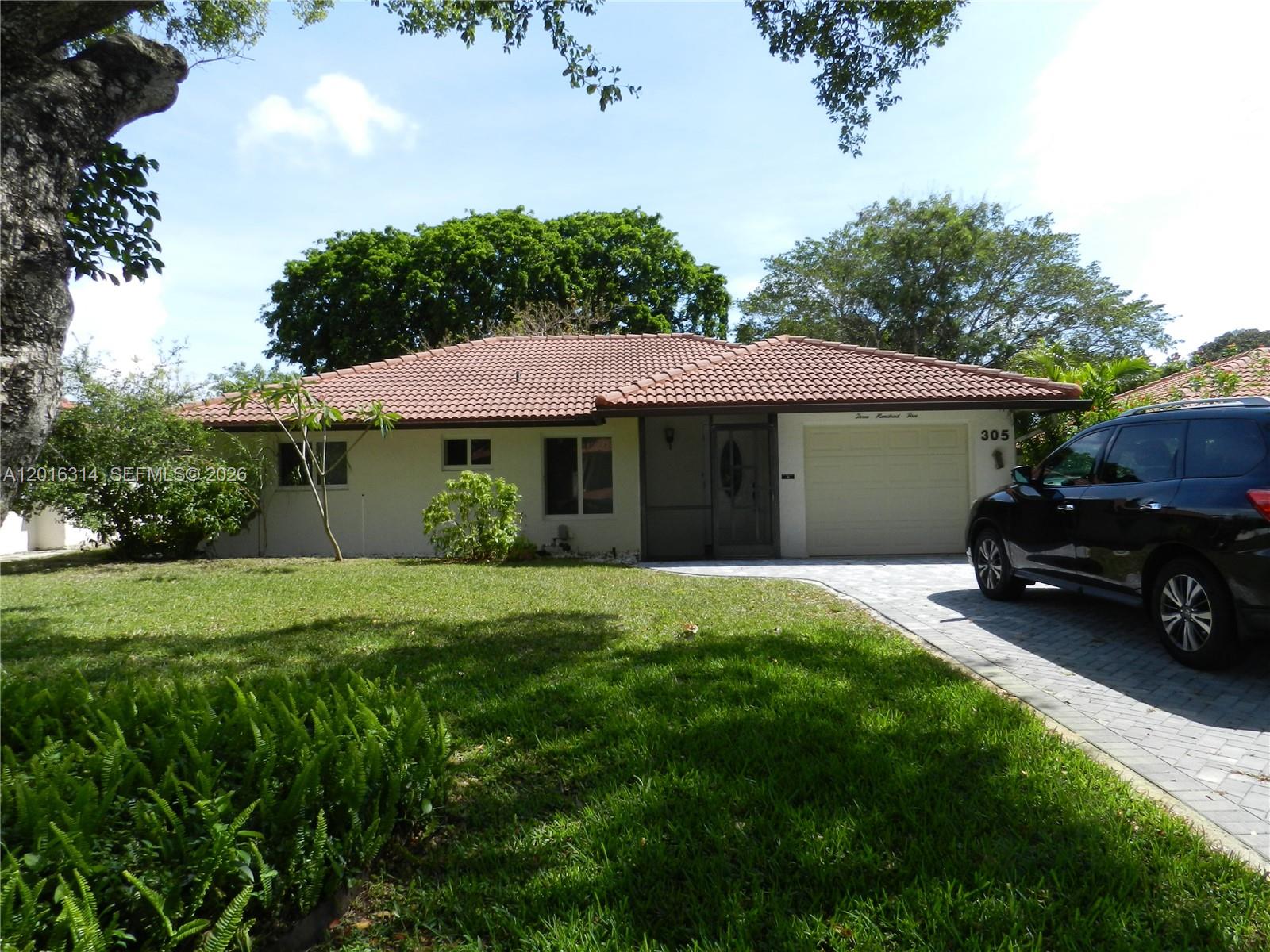 A single-story house with a tiled roof, a garage, and a paved driveway — 305 NW 42nd St, Boca Raton FL 33431, BOCA RATON, FL