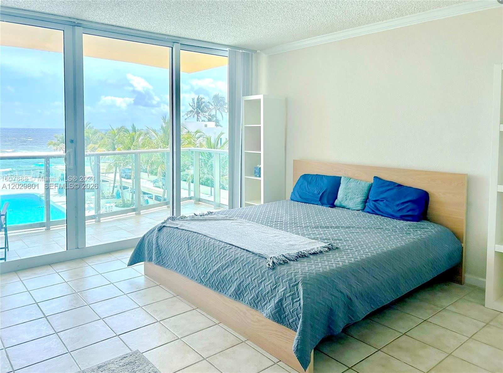 A bedroom features a bed, tile flooring, and a balcony overlooking the ocean — 2501 S Ocean Dr # 424, Hollywood FL 33019, HOLLYWOOD, FL