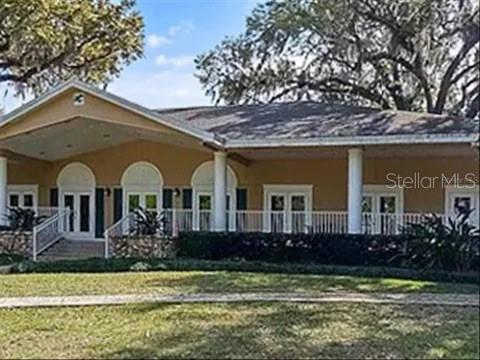 A tan, single-story building with a large covered porch, white columns, and arched doorways — 119 TOMOKA TRAIL UNIT 119, LONGWOOD, FL
