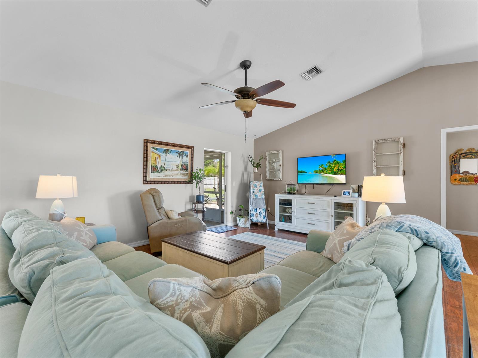 A living room features a light blue sectional sofa, a television, and a ceiling fan — 698 Fischer Drive, Sebastian FL 32958, SEBASTIAN, FL