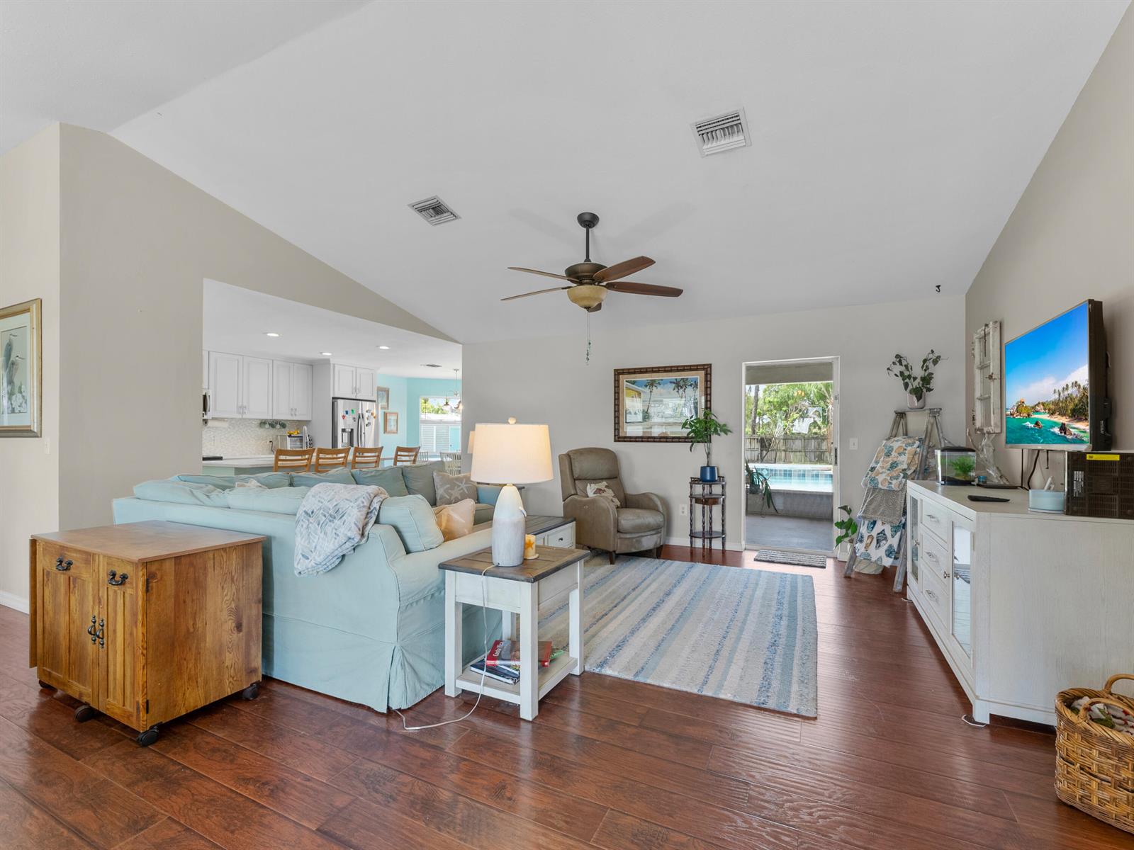 A living room with a light blue sectional, hardwood floors, and a view of a pool — 698 Fischer Drive, Sebastian FL 32958, SEBASTIAN, FL