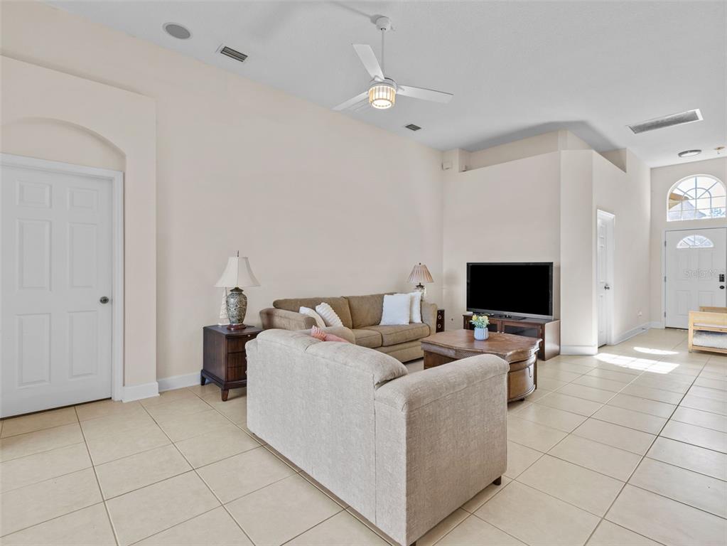 A living room features beige tile flooring, a ceiling fan, and a neutral color palette — 13235 PALMILLA CIRCLE, DADE CITY, FL