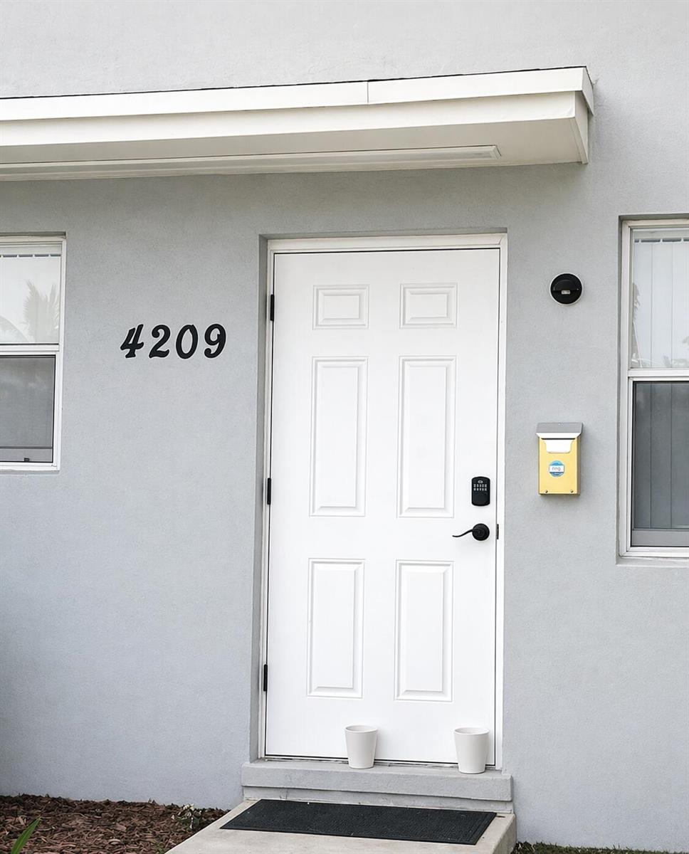 An empty room with white walls, beige tile flooring, a window, and an air conditioner — 4209 S Olive Avenue, West Palm Beach FL 33405, WEST PALM BEACH, FL