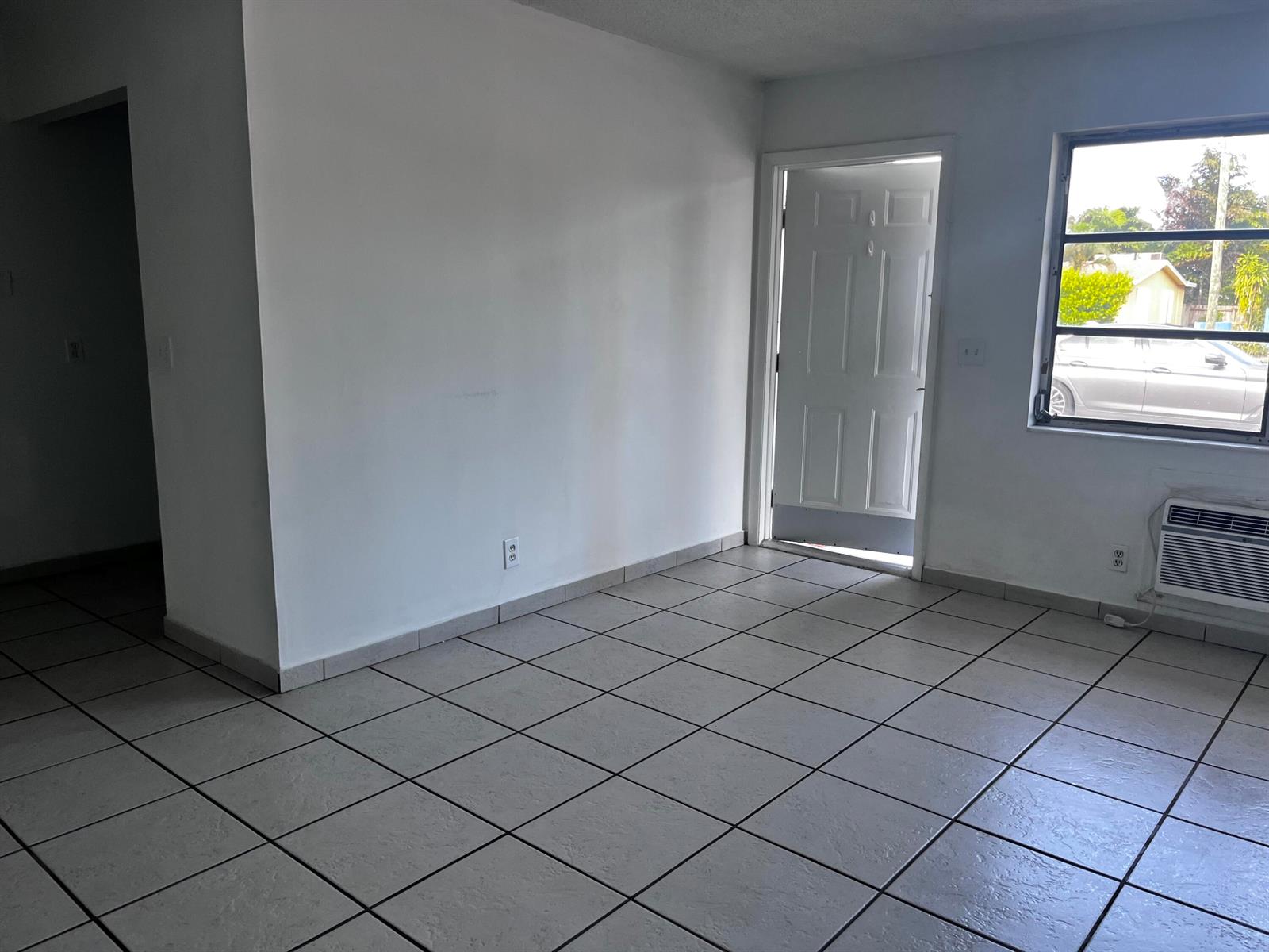 An empty room with white walls, beige tile flooring, and a window air conditioning unit — 4209 S Olive Avenue, West Palm Beach FL 33405, WEST PALM BEACH, FL