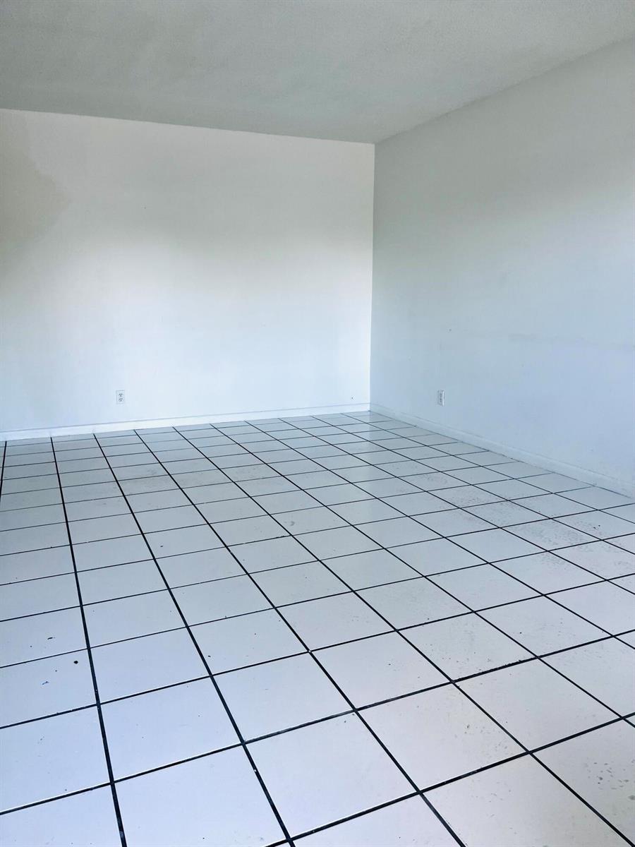 A bathroom features a wood vanity, white tiled walls, and a blue forest-print shower curtain — 4209 S Olive Avenue, West Palm Beach FL 33405, WEST PALM BEACH, FL