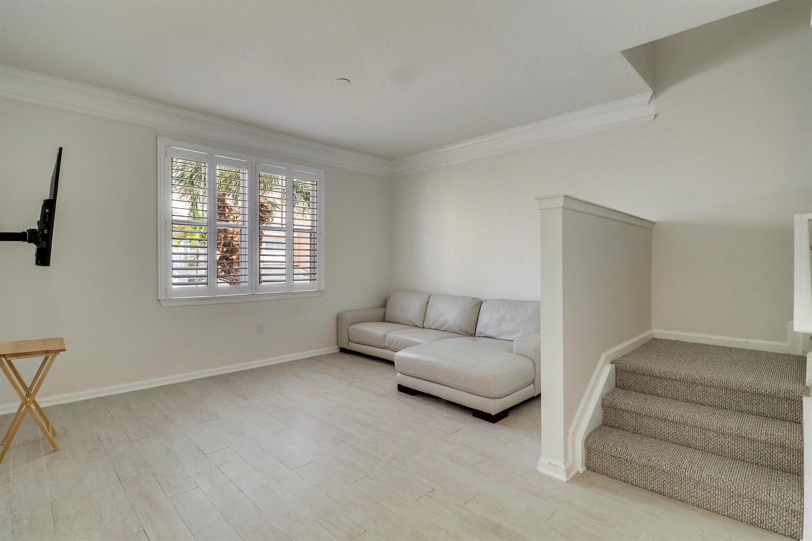 A living room with light tile floors, a white sectional sofa, and carpeted stairs — 155 Galicia Way # 204, Jupiter FL 33458, JUPITER, FL