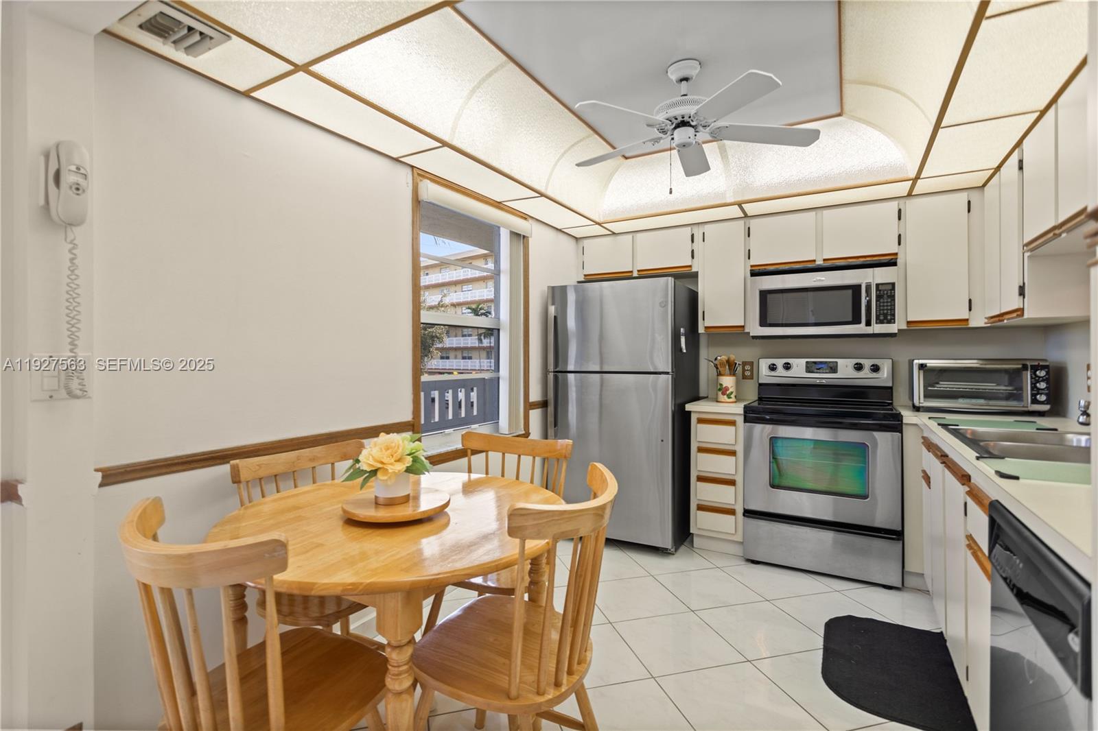 A kitchen with a dining table, stainless steel appliances, and a unique illuminated ceiling panel — 190 SE 5th Ave # 202, Dania Beach FL 33004, DANIA BEACH, FL