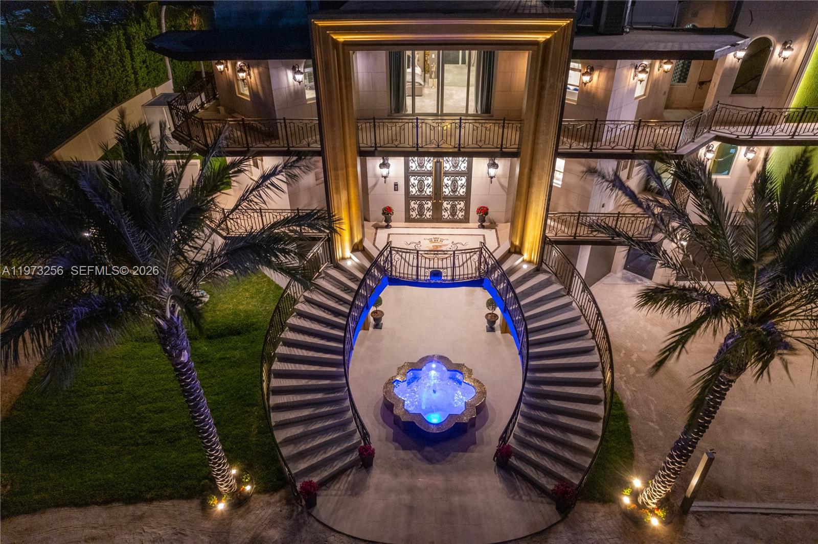 An aerial view shows a mansion exterior with a grand staircase and a lit fountain — 82719 Old Hwy, Islamorada FL 33036, ISLAMORADA, FL