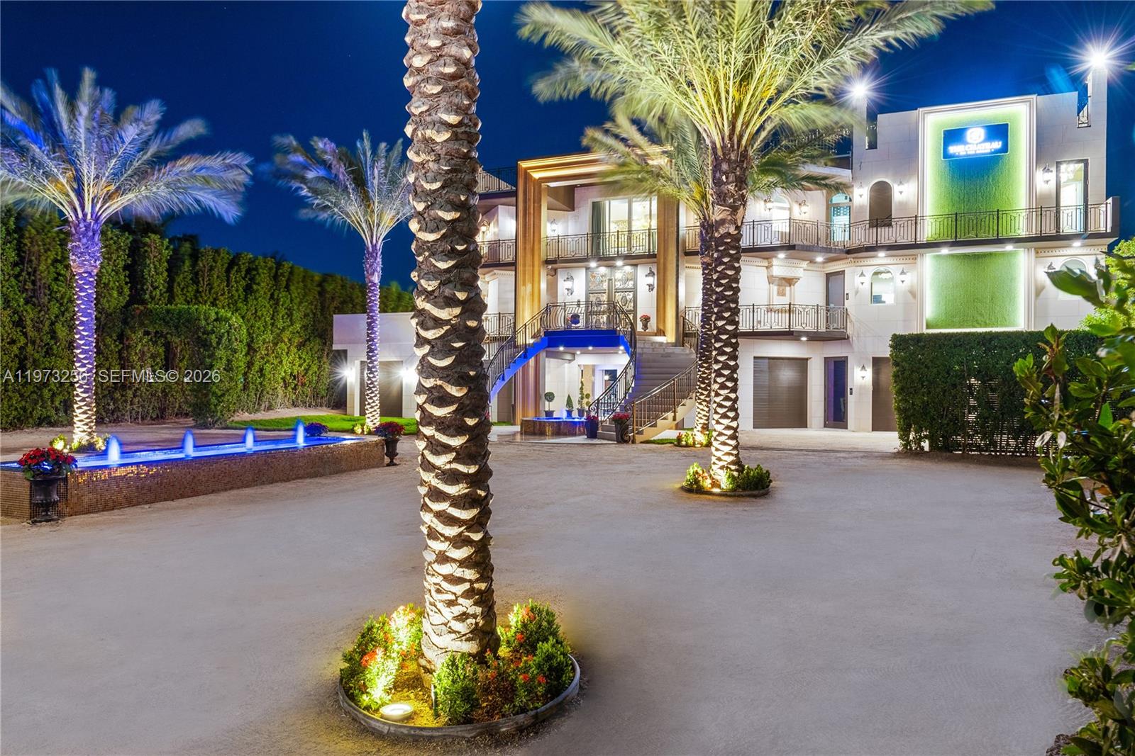 A multi-story mansion features a grand staircase, palm trees, and a lit fountain at night — 82719 Old Hwy, Islamorada FL 33036, ISLAMORADA, FL