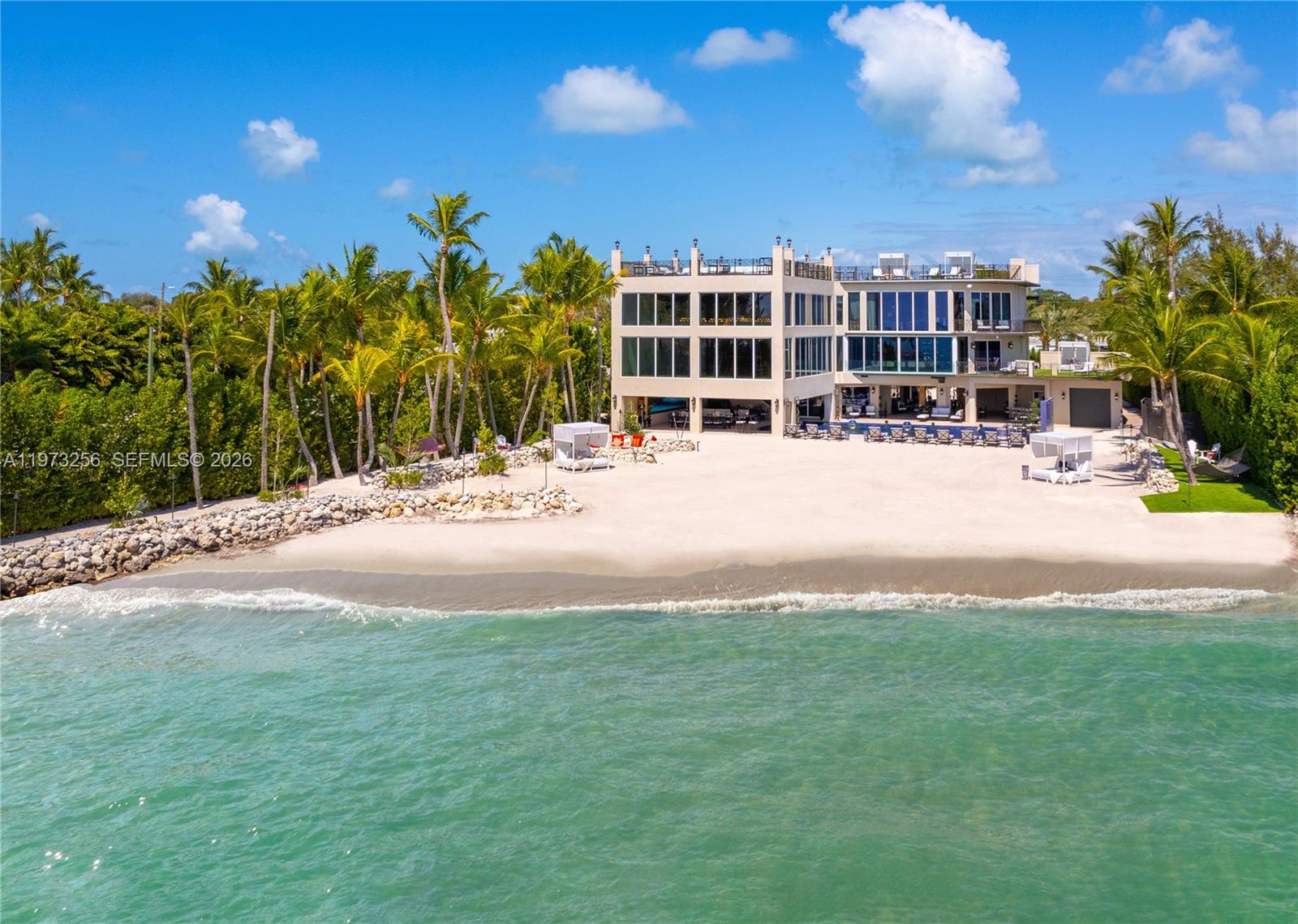 An aerial view of a multi-story modern house with a private beach and palm trees — 82719 Old Hwy, Islamorada FL 33036, ISLAMORADA, FL