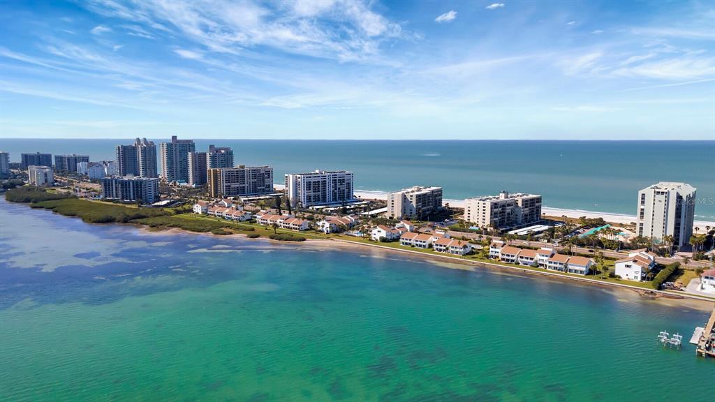 An aerial view of a coastal resort area with high-rise condominiums along a sandy beach — 1451 GULF BOULEVARD UNIT 101, CLEARWATER BEACH, FL