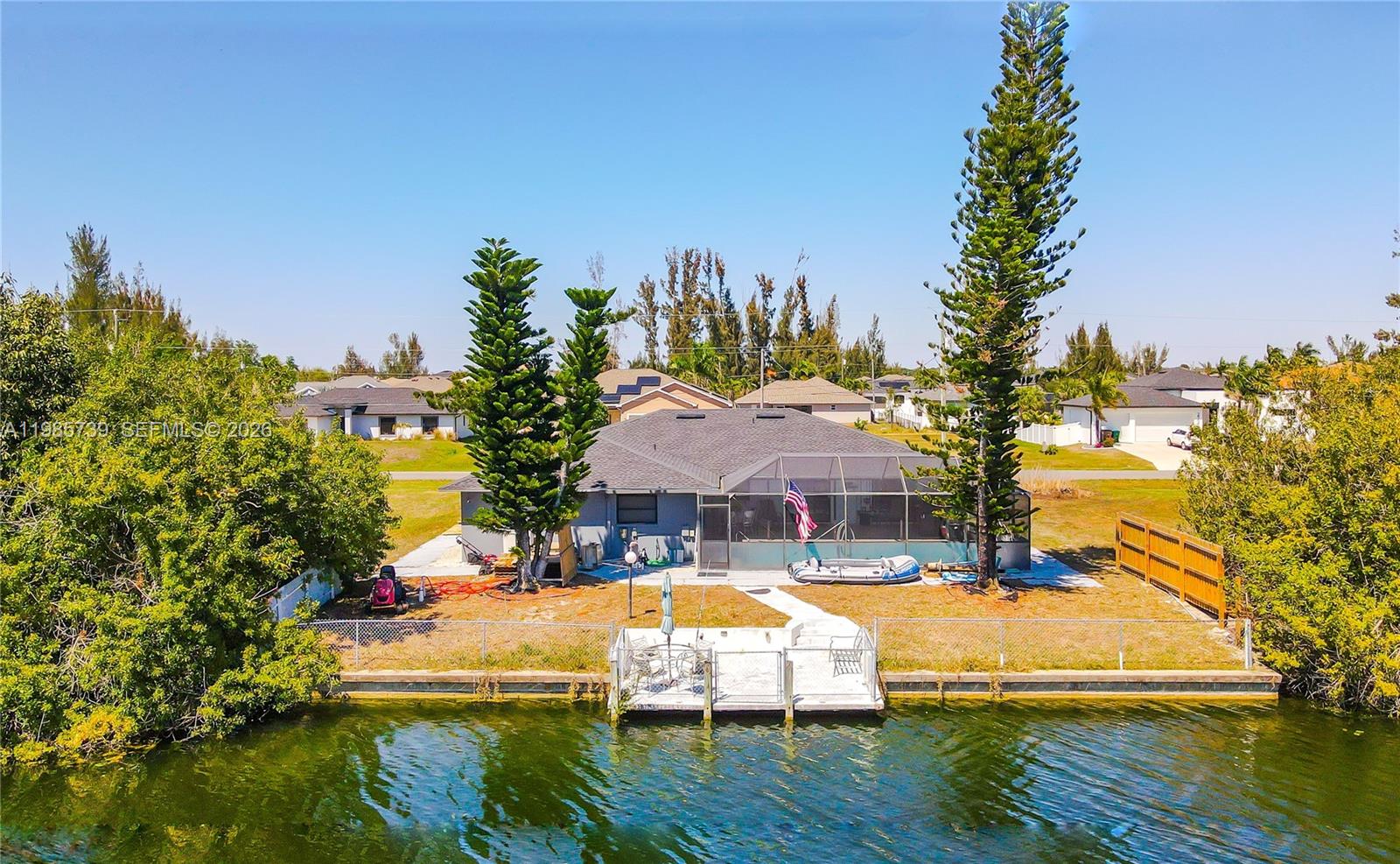 An aerial view of a waterfront house with a screened-in patio and a private dock — 2908 NW 9TH TER, Cape Coral FL 33993, CAPE CORAL, FL