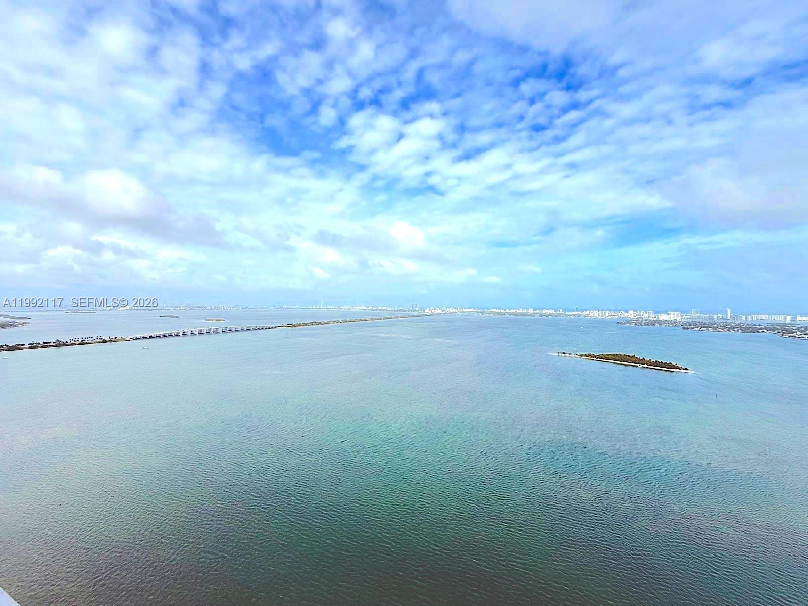 An aerial view shows a large body of water with a bridge and a small island — 700 NE 24 street # 3802, Miami FL 33137, MIAMI, FL