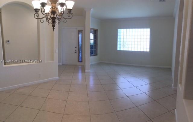 An interior view shows a tiled foyer and living area with a chandelier and glass-block window — 12400 NW 78th Mnr # 0, Parkland FL 33076, PARKLAND, FL