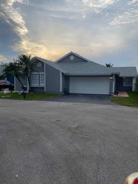 A gray, single-story house with a two-car garage and a paved driveway — 10304 SW 139th Pl, Miami FL 33186, MIAMI, FL