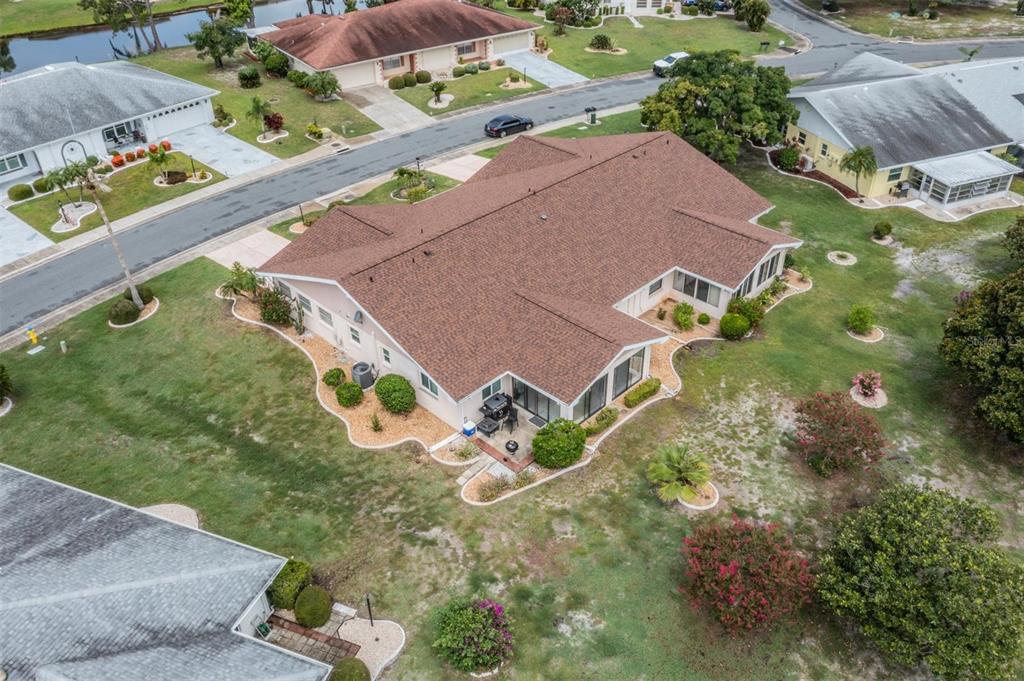 An aerial view shows a single-story house with a brown shingled roof and landscaped yard — 1209 WILD FEATHER LANE, SUN CITY CENTER, FL