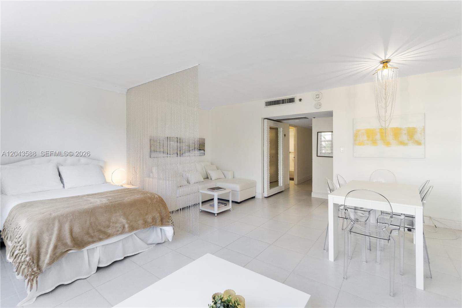 A studio apartment features a bed, a living area, and a dining table with chairs — 100 Lincoln Rd # 306, Miami Beach FL 33139, MIAMI BEACH, FL