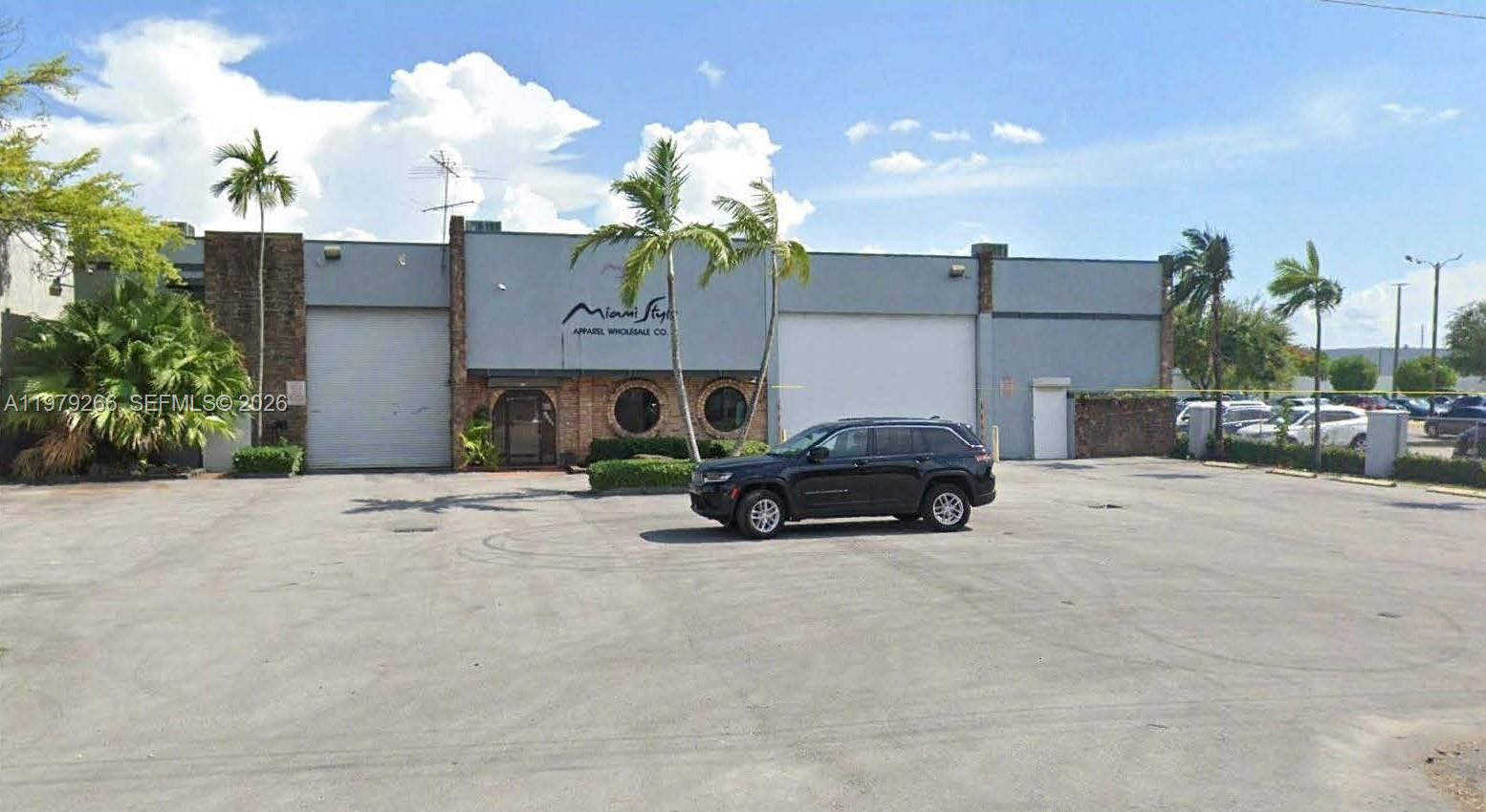 A commercial building with two roll-up doors and a parking lot in front — 7480 NW 52nd St, Miami FL 33166, MIAMI, FL