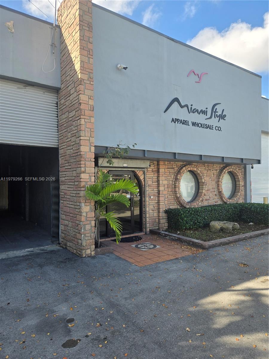 The exterior of a commercial building features a brick facade, two circular windows, and signage — 7480 NW 52nd St, Miami FL 33166, MIAMI, FL