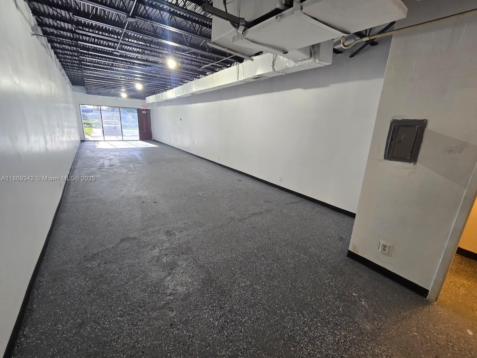 An empty commercial space features a black exposed ceiling, white walls, and speckled gray flooring — 2501 N State Road 7 # 2533, Margate FL 33063, MARGATE, FL