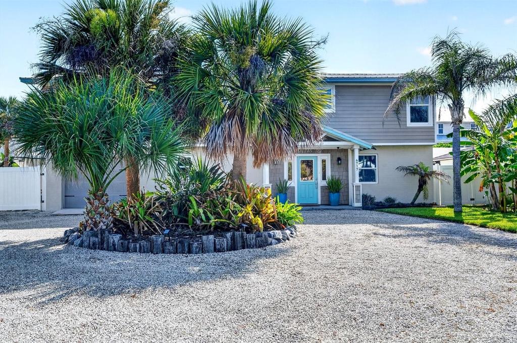 A two-story house with a gravel driveway, palm trees, and a bright blue front door — 4717 S ATLANTIC AVENUE, NEW SMYRNA BEACH, FL