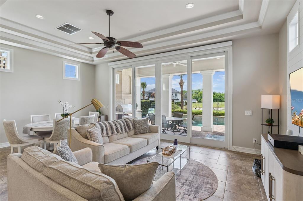 A living room with a sofa, dining area, and sliding glass doors opening to a patio — 1172 CASTLE PINES CT, REUNION, FL