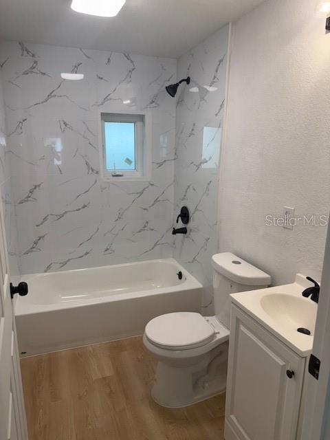 A bathroom features a white marble-patterned shower surround, a white bathtub, a toilet, and a vanity — 4605 N HUBERT AVENUE UNIT 19, TAMPA, FL