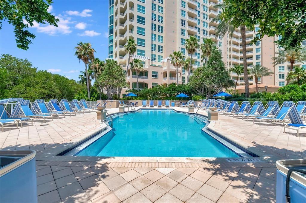 A swimming pool surrounded by lounge chairs sits in front of a tall residential building — 3700 S Ocean Boulevard # 308, Highland Beach FL 33487, HIGHLAND BEACH, FL
