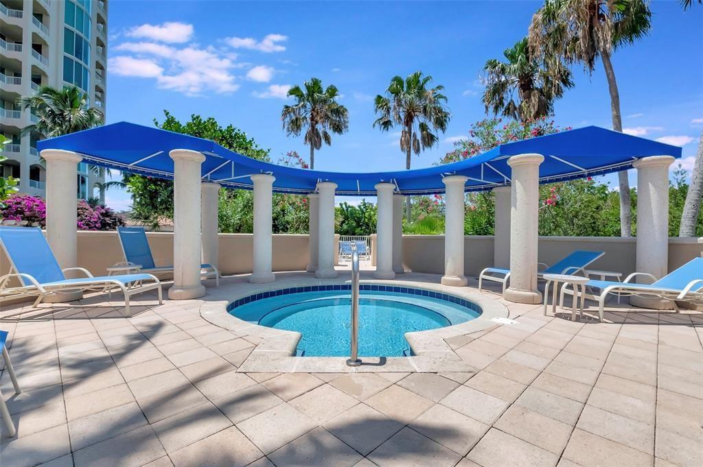 A circular hot tub is surrounded by stone columns and a blue canopy on a patio — 3700 S Ocean Boulevard # 308, Highland Beach FL 33487, HIGHLAND BEACH, FL